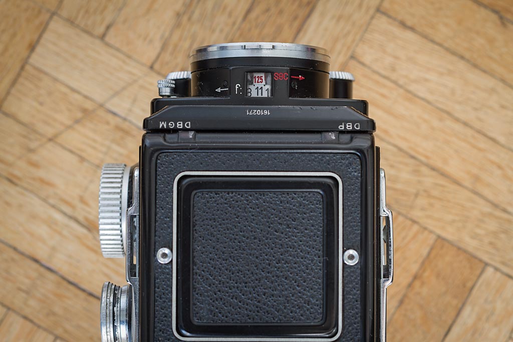 Le Rolleiflex 2.8D vu de dessus, avec le capot fermé. Les paramètres d'exposition sont clairement affichés : en rouge la vitesse d'obturation, en noir l'ouverture du diaphragme.