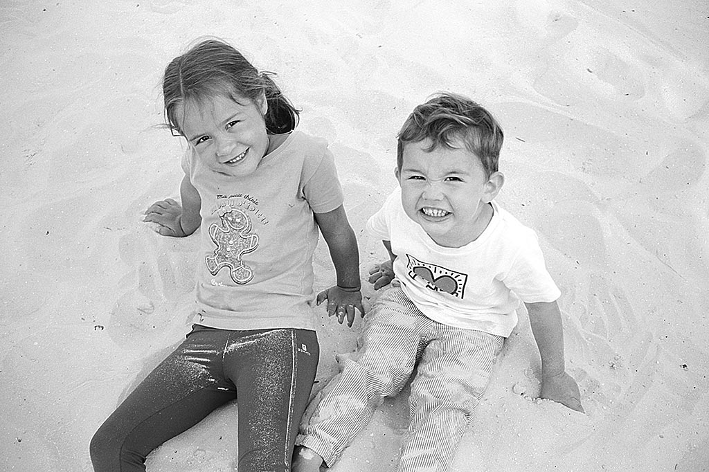 Enfants assis dans le sable. Ricoh 500G et film Kodak 100 TMax développé avec du D76.